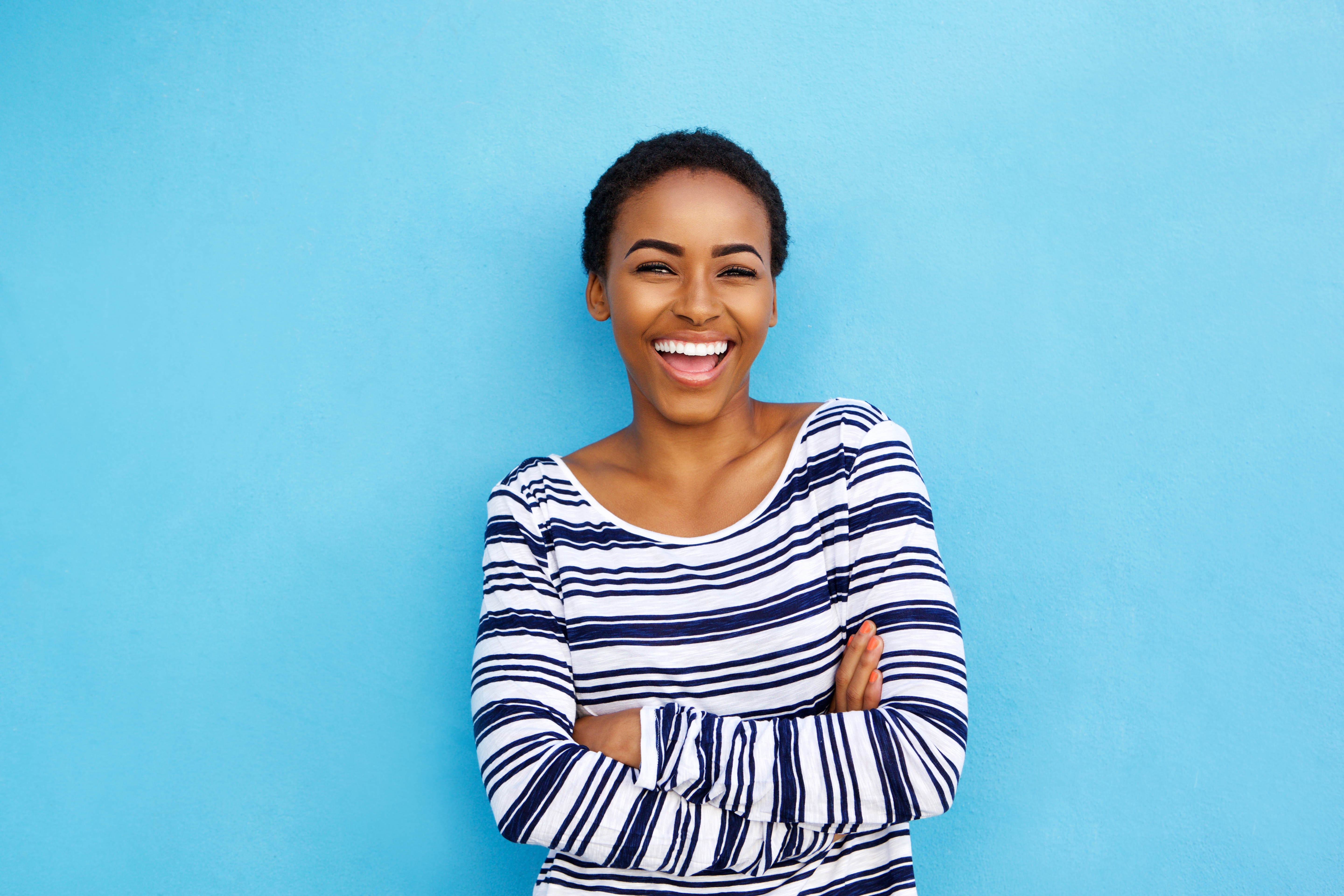 Black woman smiling on blue background